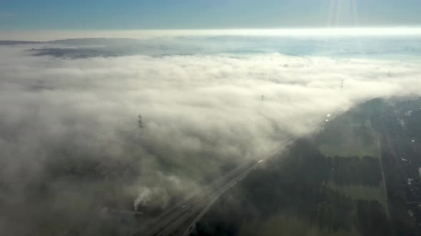 Aerial view of fog in the countryside covering a motorway