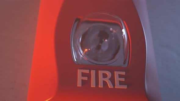 Close up shot of flashing strobe red fire alarm during fire in the room.