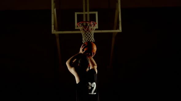 Male basketball player throwing basketball in the basketball hoop 4k