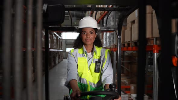 Pretty Female Warehouse Worker Driving Forklift