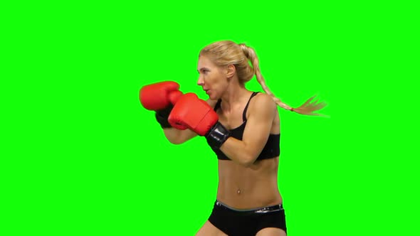 Girl Boxer in Red Gloves Beats Sends Alternating Hands. Green Screen. Side View