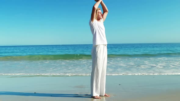 Man performing yoga at beach