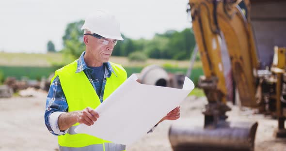 Confident Mature Male Engineer Analyzing Blueprint