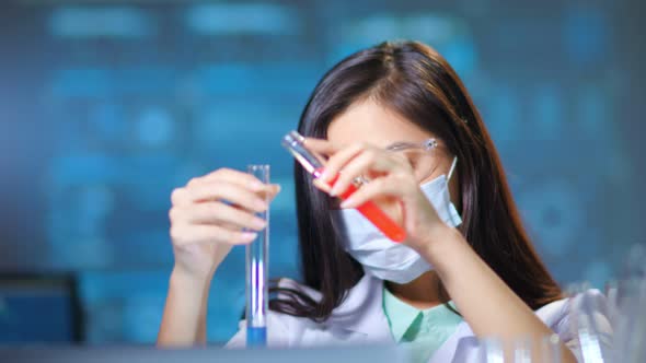 Asian Female Scientist Working with Chemical Reaction in Chemistry Lab Using Test Tube