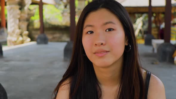 Teenage Chinese tourist explores a temple in Bali.