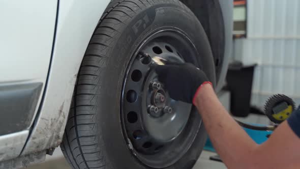 The Mechanic Installs the Panel on the Wheel to Adjust the Camber