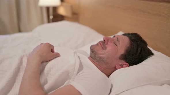 Middle Aged Man Crying while Sleeping in Bed