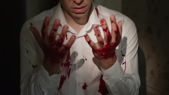 Scared Man Looks at His Bloody Hands