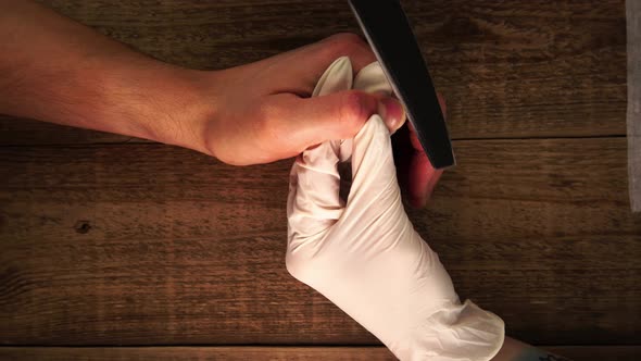 Closeup View of Female Nail Master Making Manicure to a Male Client Using a File Filmed From Above