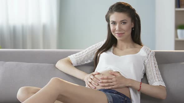 Future Mother Touching Stomach, Looking Into Camera and Smiling, Clinic Advert