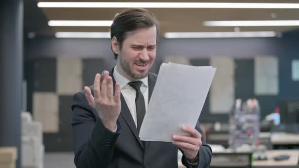 Businessman Having Loss While Reading Documents