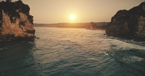 Slow Motion Sunset at Rock Ocean Shore with Waves at Watersurface Aerial View