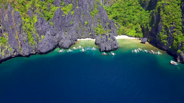 Tourist Boats at The Beach and Rocks Outside the Secret Lagoon on Miniloc Island in the El Nido