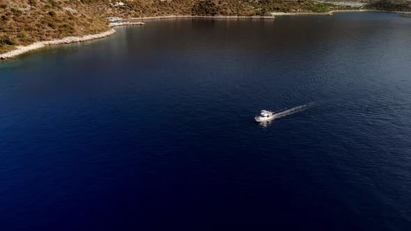 Small Boat Floats on Sea or Ocean Next to Shore