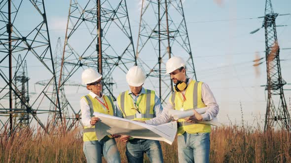 Engineers Are Walking Near Electrical Towers and Discussing a Layout