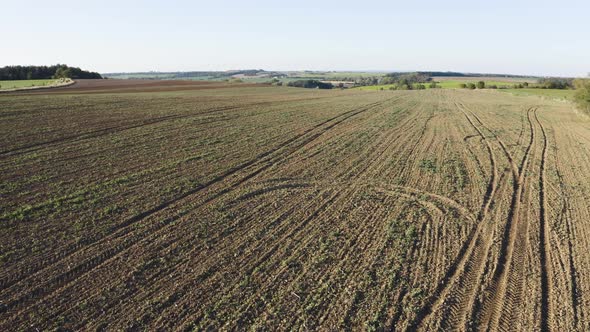 Aerial Drone Shot  a Field with a Tractor and a Road in a Rural Area on a Sunny Day  Drone Ascends