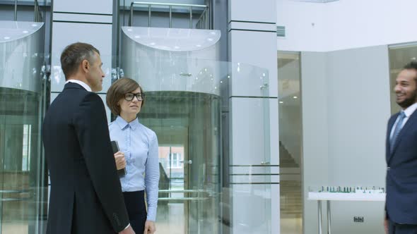 Cheerful Colleagues Shaking Hands in Modern Office Center