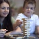 Mother and Son Playing in Board Game with Wooden Tower at Home - VideoHive Item for Sale