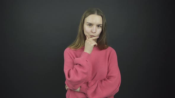 Thoughtful Girl with Long Loose Hair Holds Hand on Chin