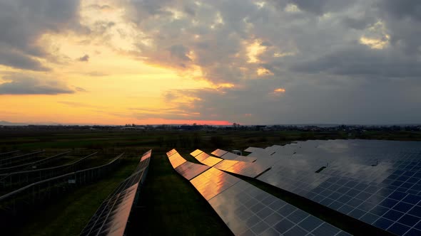 Solar power plant at Sunrise. Bird's-eye. Drone flying over a Solar Farm. Renewable green energy.