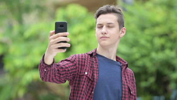 Young Happy Teenage Boy Taking Selfie Outdoors