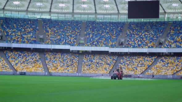 Tractor Watering the Lawn on the Big Stadium