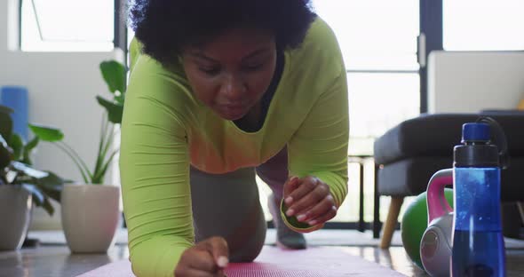African american female plus size lying on exercise mat working out