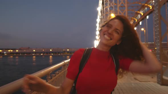 Ecstatic Woman Laughing and Walking along Bridge