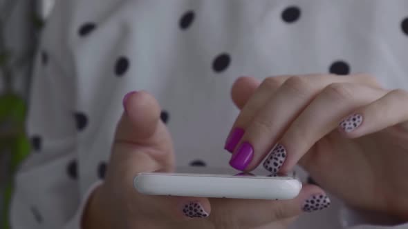 Manicured Female Hands with Stylish Pink Nails Holding Mobile Phone