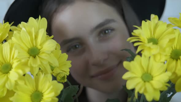 The girl is hiding behind flowers. 