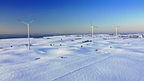 Wind turbines on snowy field. Alternative energy, Poland.