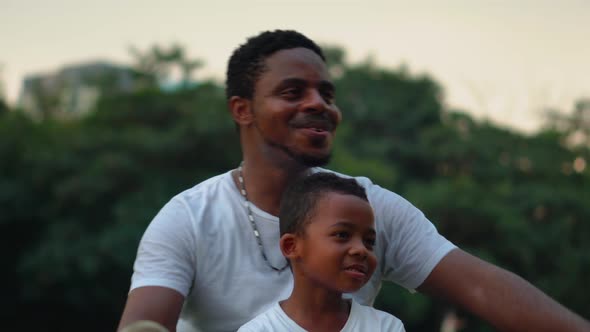 Cheerful African American father and son playing in park, Happiness family concepts