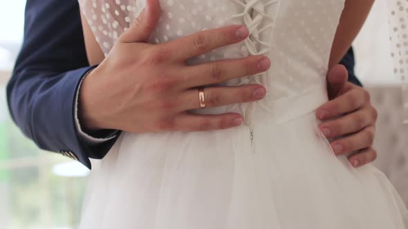 The Groom Gently Hugs the Bride and Strokes the Back with His Hand