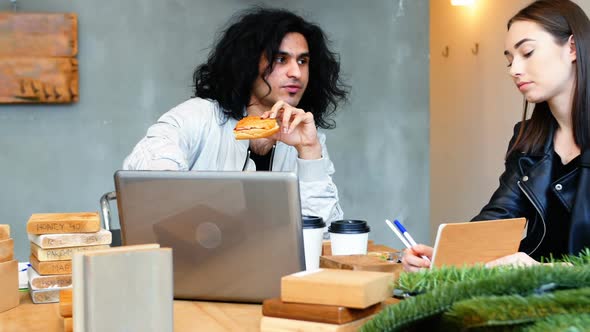 Executive discussing over laptop while having breakfast