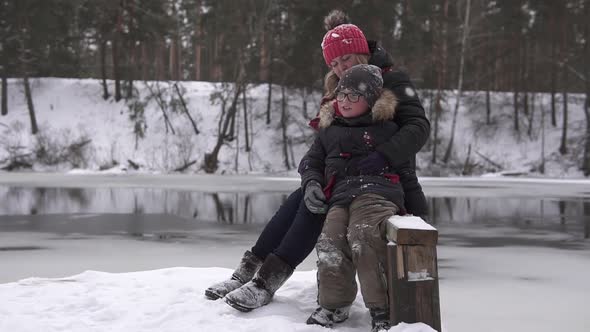 A winter walk of a mother with a child near the reservoir. Time spent in quarantine.