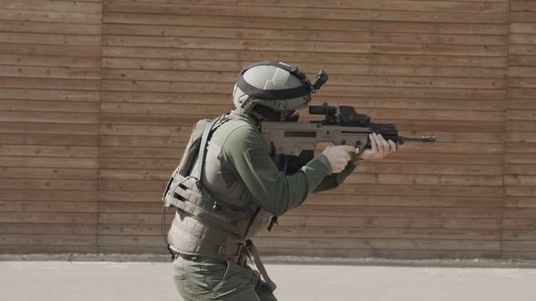 Slow motion of soldier shooting automatic rifle in a range alt