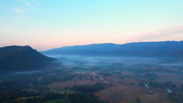 4K aerial view over mountain scenery rural Thailand at sunset