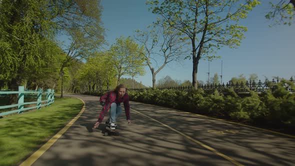 Cool Hipster Charming Woman Skateboarder Skateboarding in Public Park