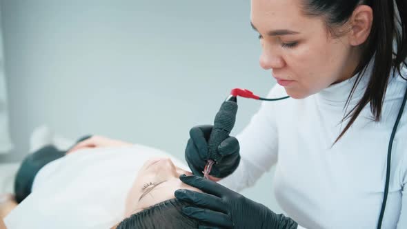 Cosmetologist Making Eyebrow Permanent Makeup