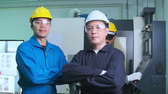 portriat of active cheerful asian engineer manager and co worker staff standing in factory workshop