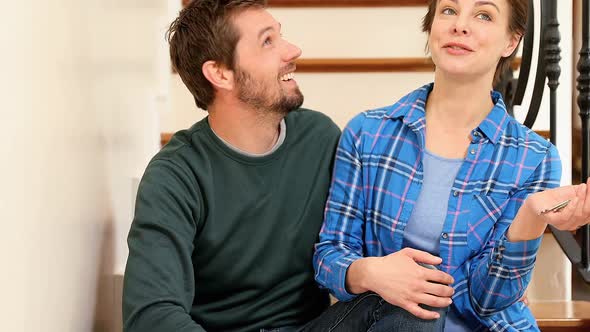 Smiling couple sitting on staircase talking with each other 4K 4k