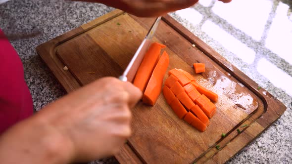 Cutting Peeled Carrot Vertically With A Sharp Knife. close up