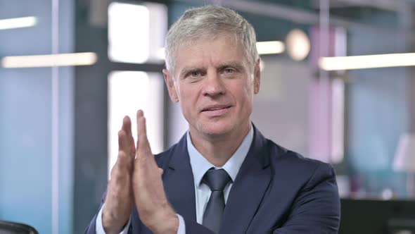 Portrait of Middle Aged Businessman Clapping with Hands