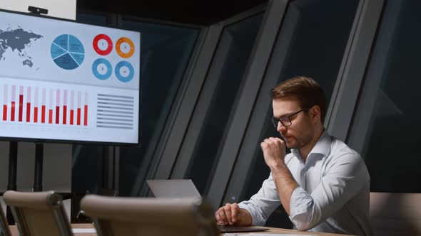 Serious young worker typing on laptop keyboard