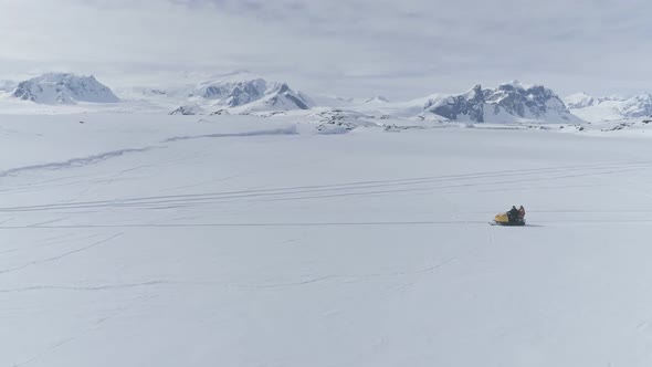 People Riding on Vintage Snowmobile. Antarctica