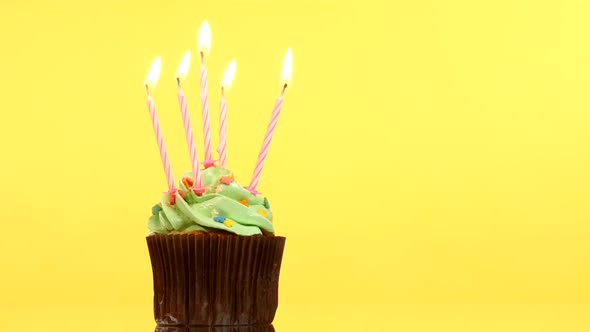 Tasty Birthday Cupcake with Five Candle, on Yellow Background