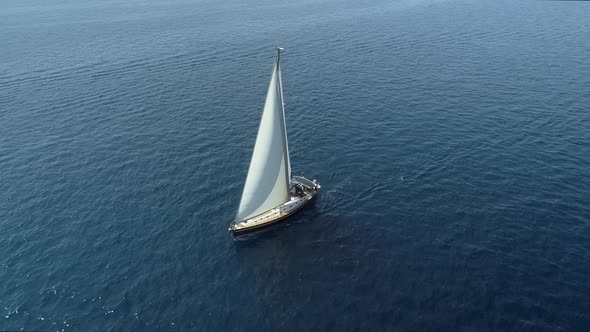 Aerial view of a sailboat driving in the mediterranean sea, Vathi, Greece.