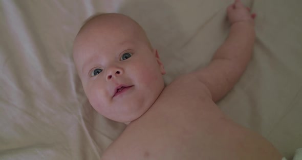 Beautiful Smile at Camera of Cute Naked Newborn Baby alt