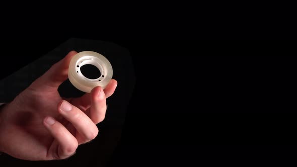 Office Worker Holds Scotch Tape In Hand On Black Background