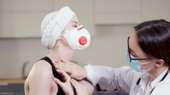 Closeup of Professional Caucasian Female Doctor Examining Patient in Covid19 Respirator Indoors